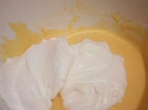  盛1/3蛋白到蛋黄碗里，翻拌均匀(从底部往上翻拌，不要画圈搅拌)。