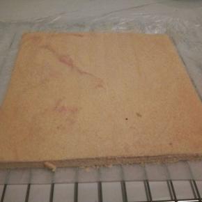  烤好的蛋糕，震一下，然后立马移动到烤网上，（烤网上面垫一张油纸）迅速撒掉原来蛋糕上的油纸，马上再把蛋糕翻回来，晾一会，