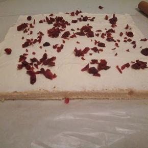 用刮刀把奶油铺在上面，再撒蔓越莓碎