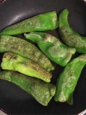 边煎边用铲子把薄皮青椒按压一下，中途记得翻面！让薄皮青椒煎出均匀地虎皮色即可捞出控油备用。
