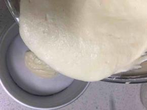 分两次把蛋白加入蛋黄糊里，轻轻搅拌，搅拌好后倒入垫有油纸的模具里