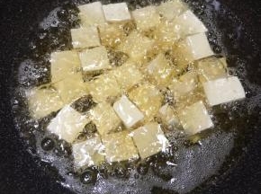 锅中加入多一些的油，大火烧至7成热，下入豆腐中火炸制。
