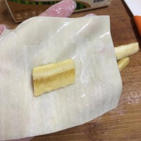 取一张云吞皮，一端沾少许清水，放入香蕉。
