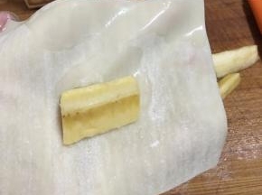 取一张云吞皮，一端沾少许清水，放入香蕉。