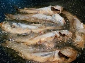  锅里放适量油，油温用筷子试一下，筷子周围冒小泡泡就可以中火炸了！梅鱼底下定型再翻面，