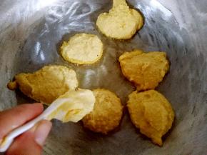 热锅冷油，油热时用勺子舀入玉米面糊，用勺背摊开