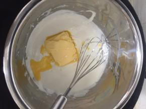 锅内倒少许水加热，
把刚刚搅拌好的奶酪糊坐于锅里热水内，加黄油搅拌