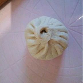  揉一下，我分了16个面团，每个大概48克左右，. 擀皮，中间厚一点，两边稍薄一点， 加了2勺馅料包起来，