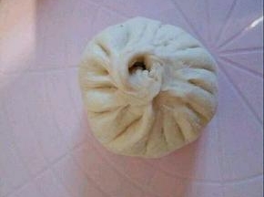  揉一下，我分了16个面团，每个大概48克左右，. 擀皮，中间厚一点，两边稍薄一点， 加了2勺馅料包起来，