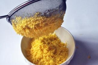 把蛋黄放筛网上，用手指按压，使蛋黄通过筛成蛋黄细末。