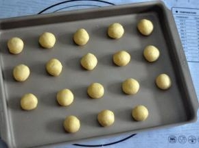 取出后15克一个小圆球称重,放入正的13寸烤盘，刚好可以放入38L左右烤箱的卡槽，大容量，一次烤得更多，注意球与球之间的距离，在烘烤的过程中，杏仁酥会变大。