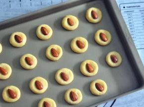 放入整颗的杏仁，轻轻的压一下，表面刷上少量的蛋液。