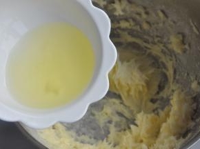 倒入一半的蛋清，让蛋清与黄油充分打发。