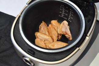 将腌制好的鸡翅放入电饭煲