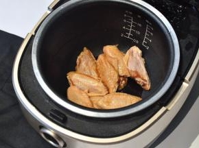 将腌制好的鸡翅放入电饭煲