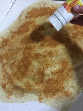 把孜然粉装进料盒里，均匀地撒在上面！（这个料盒是我自己把装钙片的瓶子的瓶盖钻了几个孔做的，很好用。）

