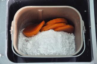 将蒸过的南瓜沥干水份，南瓜水放一边备用，将南瓜、糯米粉、糖粉放入面包机中，启动10分钟揉面程序（如果没有面包机，那么可以将南瓜剁成南瓜泥，手动将南瓜泥与糯米粉揉成光滑的面团）刚开始会比较干，慢慢糯米粉与南瓜融合到一起，揉到面团成形，由于南瓜的水份不同，根据情况适当增加南瓜水或者糯米粉，揉成软硬适中的面团。