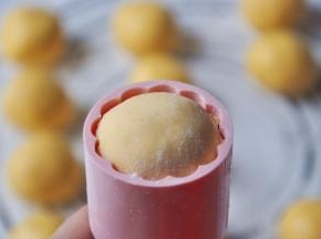 取一个小球也裹上少许糯米粉，装入法焙客月饼模。（提前给模具做防粘处理，在里面涂一层糯米粉，涂好后轻轻拍掉多余的粉。）