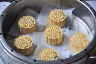 将做好的南瓜饼胚垫上油纸放入蒸格，蒸锅里加水烧开后，放上蒸格蒸15分钟。