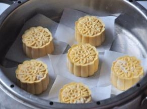 将做好的南瓜饼胚垫上油纸放入蒸格，蒸锅里加水烧开后，放上蒸格蒸15分钟。