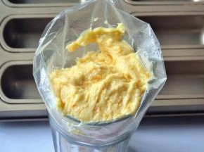 将面糊装入裱花袋，挤入磅蛋糕模具中。