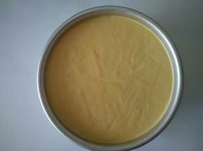 模具底部放一张八存的油纸，戚风蛋糕胚放在上面，倒入混合好的芒果奶油糊放冰箱冷藏2个小时