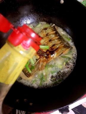 倒入一勺红烧酱油转小火继续慢慢的煮，让鱼充分的入味儿。

