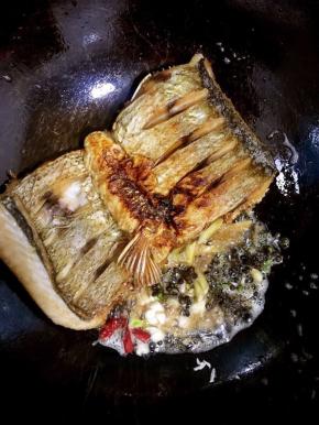 把煎好的鱼拨到一边，放入生姜，新鲜的花椒，蒜瓣，干辣椒炒出香味儿！

