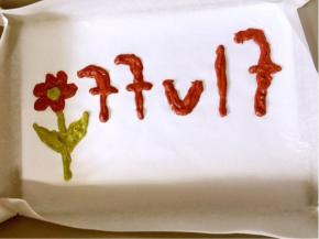 裱花袋剪一个小口，把刚才画好的文字和图案填满！


