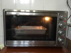 烤好后取出放在烤架上散热！重新准备一张干净的油纸，把蛋糕卷倒扣在油纸上，轻轻地撕去油纸。

