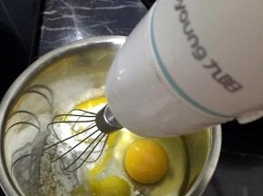 鸡蛋和蛋黄打入打蛋盆里，加入糖，用电动打蛋器打至浓稠