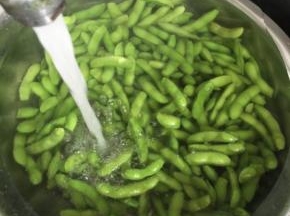 煮好的毛豆捞出来沥干水份，迅速放在水龙头下冲洗几遍，直到毛豆彻底变凉即可！

