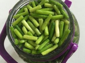 把玻璃瓶清洗干净后擦干水分，把蒜苔装进去，边装蒜苔边用手使劲按压，使蒜苔按压紧实！

