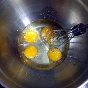 蛋黄里加入玉米油，水，用手动打蛋器搅匀