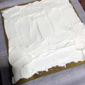 抹上奶油，奶油抹在开始卷的一边多些，边边留些空白，借助擀面棍卷起来，放入冰箱冷藏1个小时定型就可以了