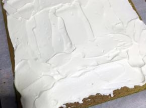 抹上奶油，奶油抹在开始卷的一边多些，边边留些空白，借助擀面棍卷起来，放入冰箱冷藏1个小时定型就可以了