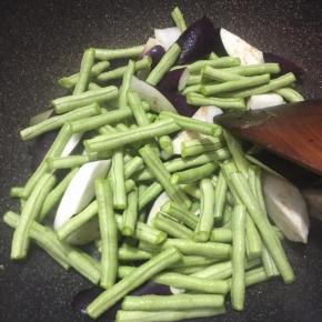 下入沥干水分的茄子与豆角翻炒几下。