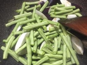 下入沥干水分的茄子与豆角翻炒几下。