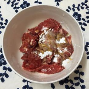 牛肉切薄片放入碗中，加入玉米淀粉、酱油和少许玉米油用手抓匀备用。