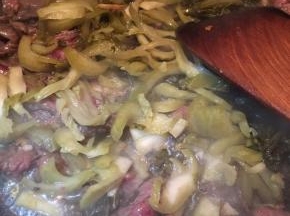 炒至牛肉微微变色，加入酸菜不停翻炒。