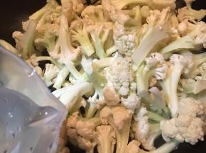 倒入花菜，加入少许清水。