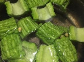 将排骨、苦瓜和黄豆一同倒入锅中，加入6-8碗清水。