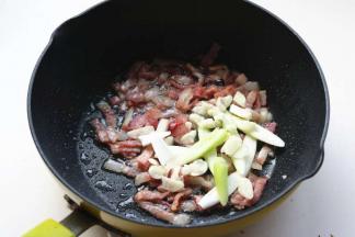 炒锅放少量油，煸香培根后，放入葱蒜爆出香味。