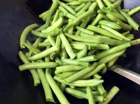 倒入豆角翻炒，煎至焦焦的好吃