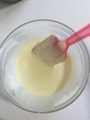 将混合好的面糊舀少部分到牛奶和油的混合物中，快速翻拌均匀。


