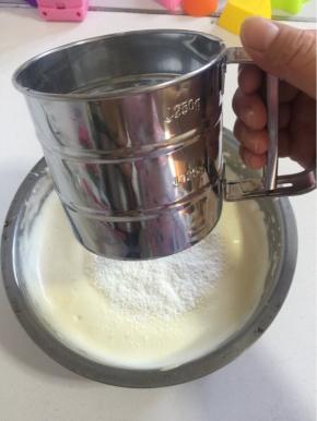 将过筛后的低筋面粉分三次加入到打好的蛋液中。

