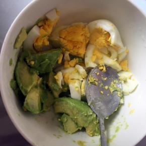 用勺子挖出来果肉放入碗里，鸡蛋去壳一起放入牛油果碗里，用勺子捣碎