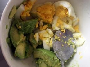 用勺子挖出来果肉放入碗里，鸡蛋去壳一起放入牛油果碗里，用勺子捣碎