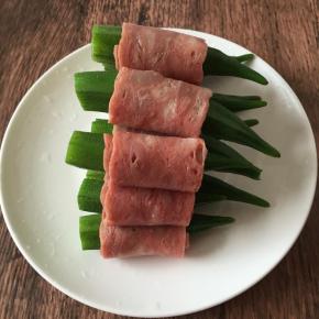 捞出凉水冲一下沥干水备用，培根对半切开，把秋葵一个一个卷起来