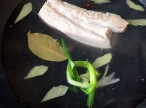 猪肉洗净，拔净残毛，葱姜洗净，姜切片，锅里烧开水，放入料酒，八角，桂皮，葱打结，姜片煮30分钟至8成熟